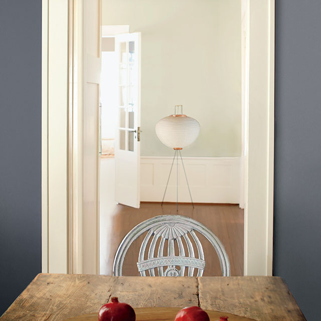 Rustic plank table with gray-blue wall and pomegranates