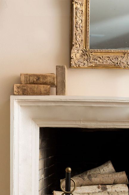Fireplace mantle with vintage mirror and books