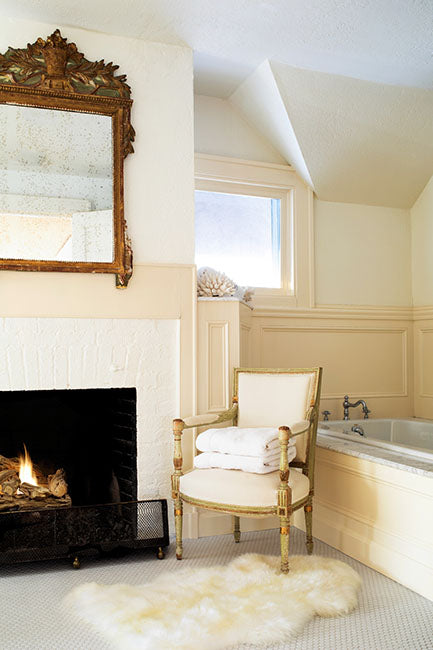 Luxurious master bathroom with fireplace and armchair