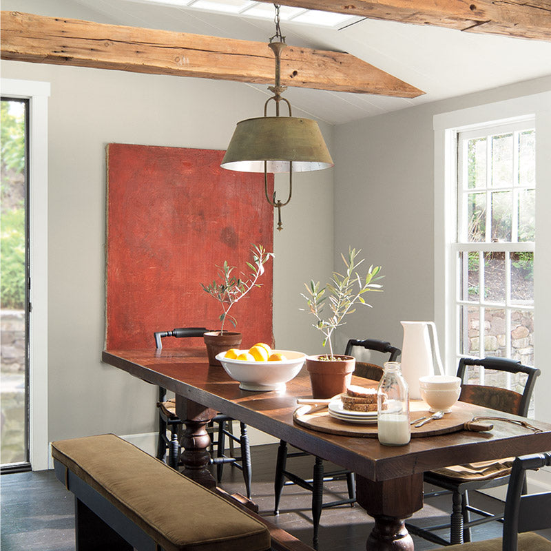 Dining room with neutral gray walls and exposed ceiling beams