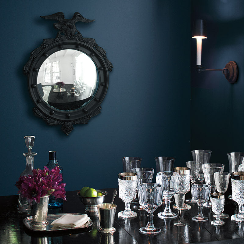 Table with a variety of glasses against a deep blue wall.
