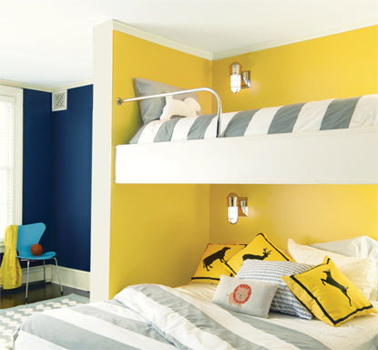 A yellow-painted kid's bedroom with gray and white bunk beds.