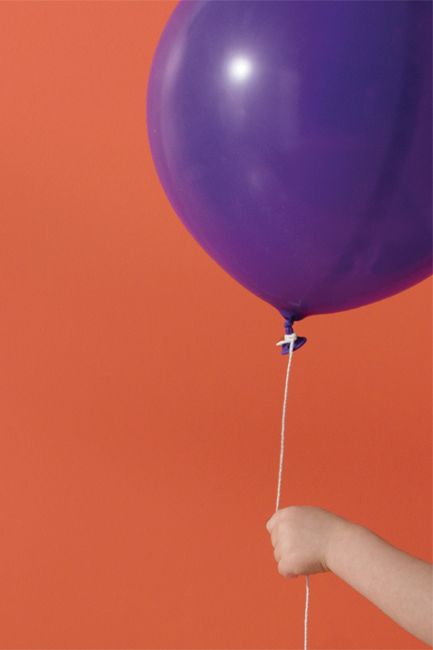 An orange-painted wall frames a purple balloon.