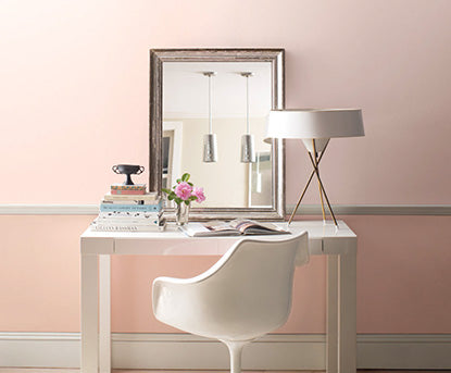 White desk along pink accent wall.