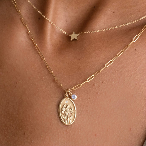Woman wearing layered necklaces, featuring Starling Jewelry's Birth Flower Charm