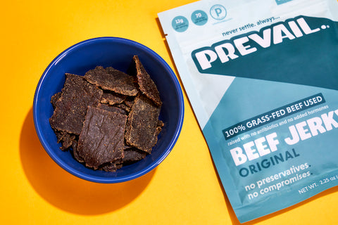 A pack of PREVAIL jerky next to a bowl of jerky