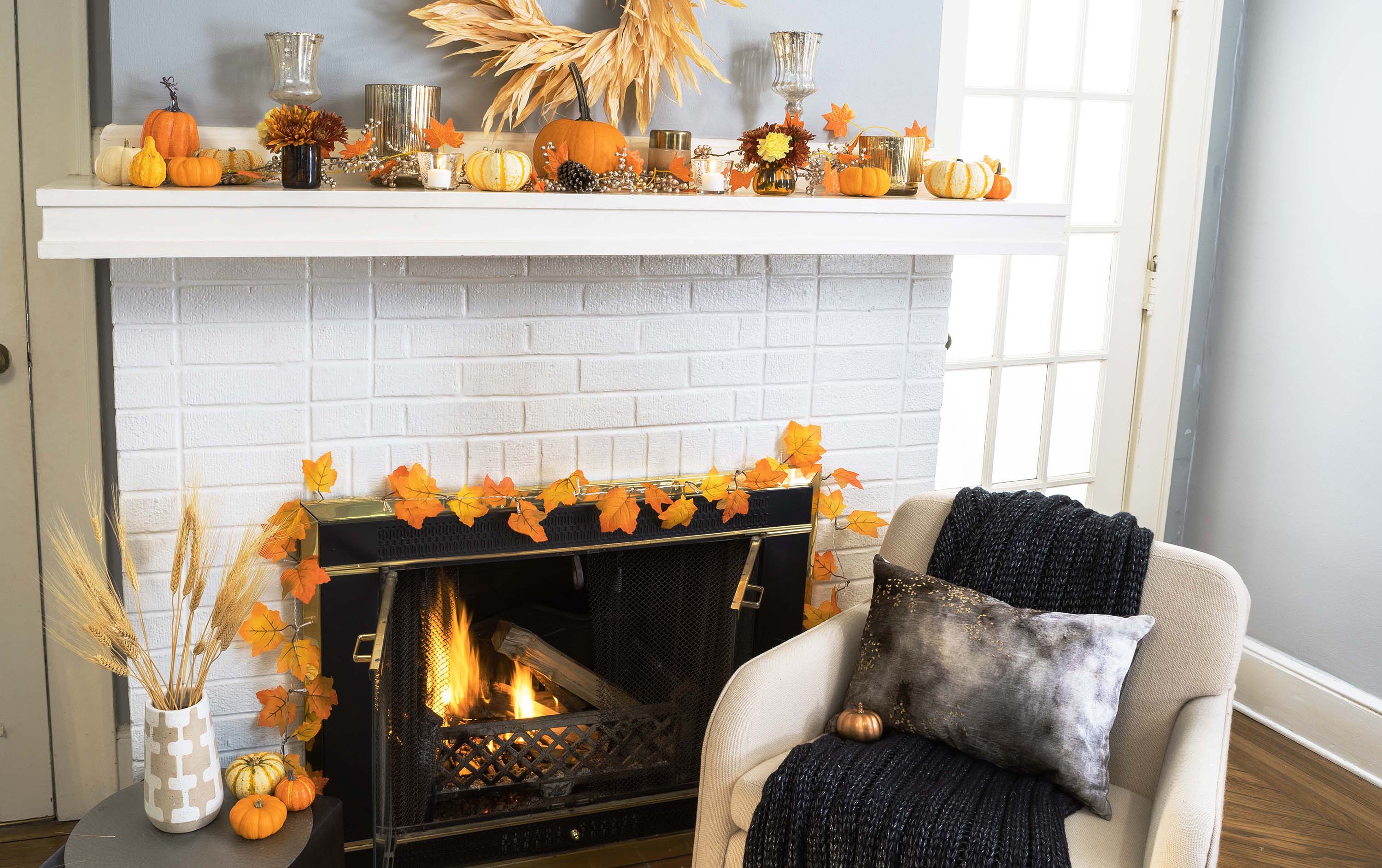 a fireplace mantel with darker fall decorations