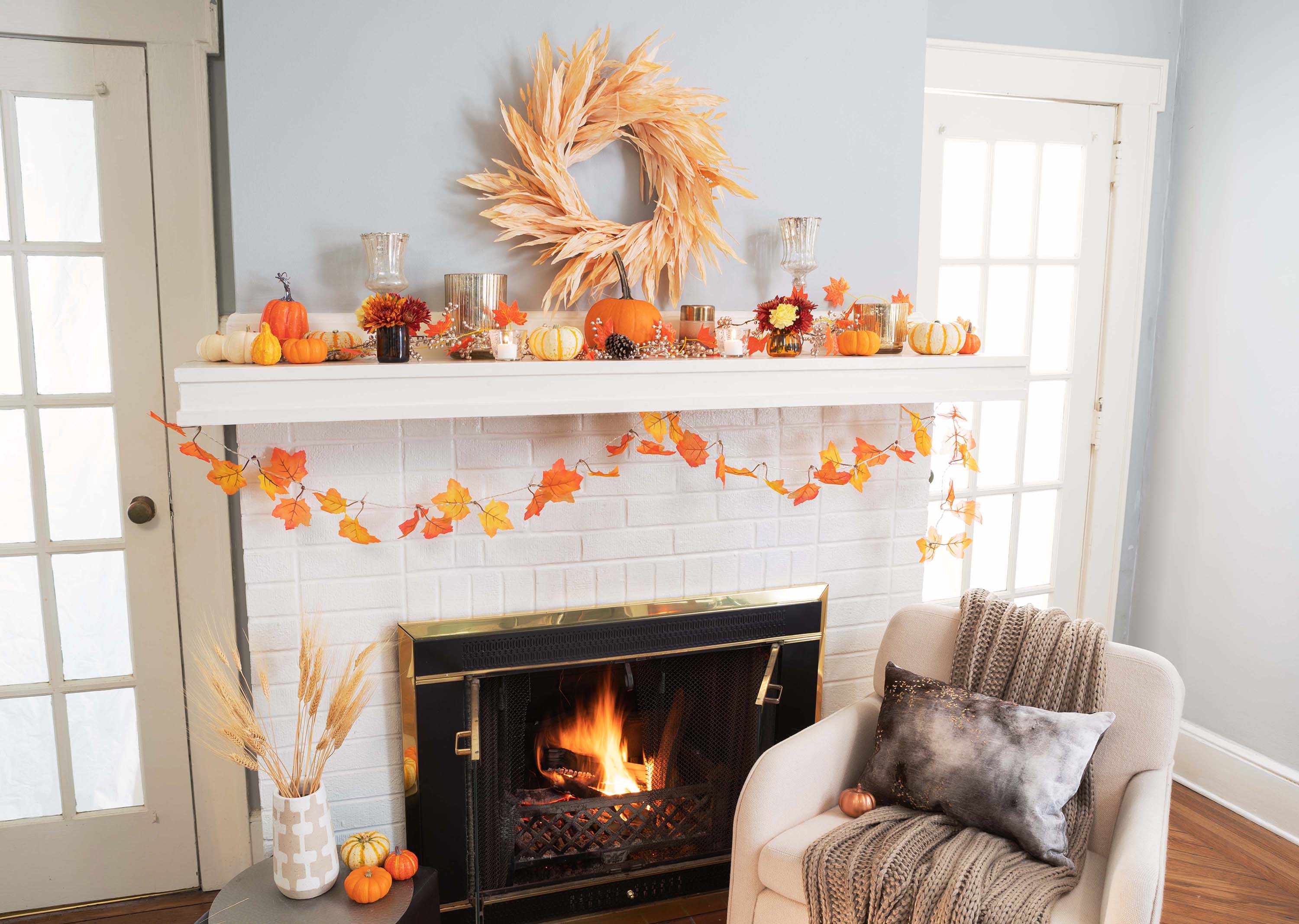 A fireplace mantel with fall decorations