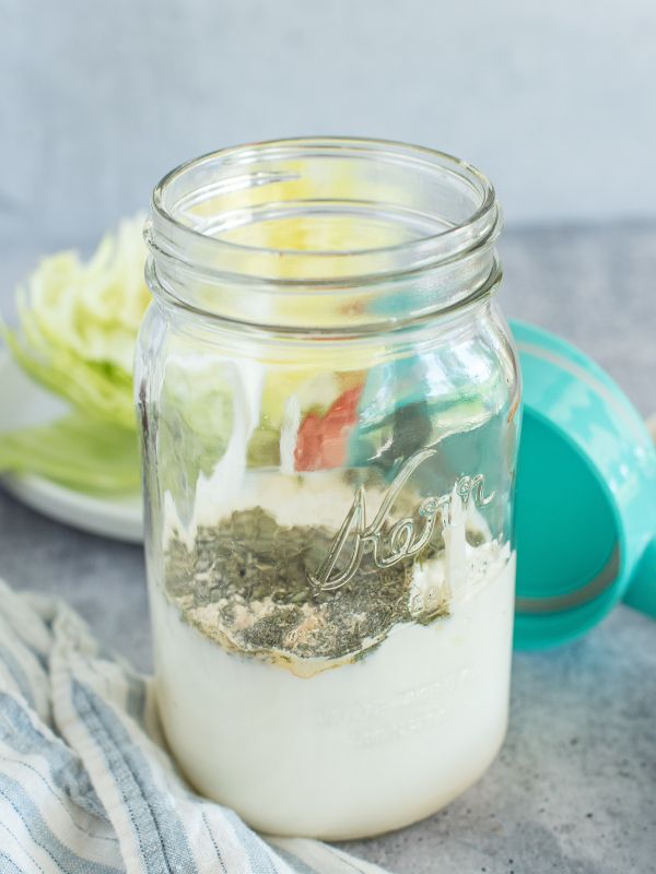 Ingredients for buttermilk ranch dressing in a wide mouth mason jar before it's mixed.