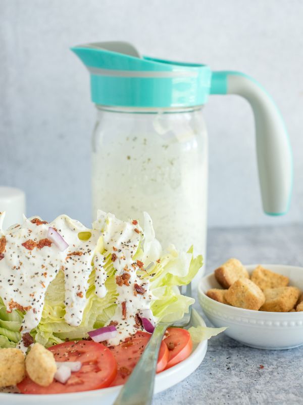 Wedge salad with buttermilk ranch dressing in the foreground with a mason jar of dressing with an Ergo Spout WIDE in the background.
