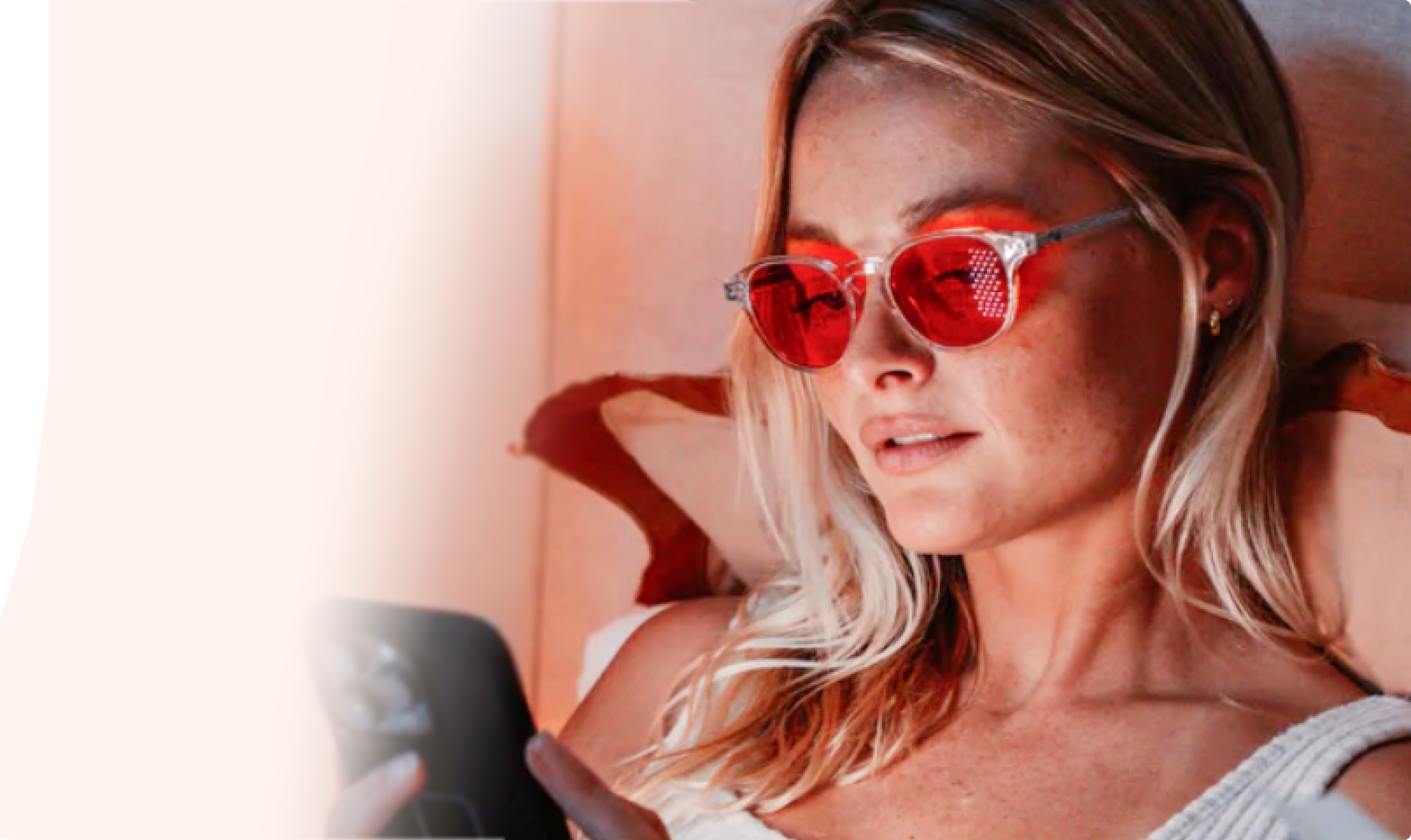 Woman with red sunglasses looking at her smartphone.