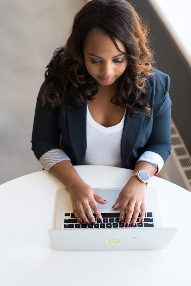 woman typing at desk making a student resume