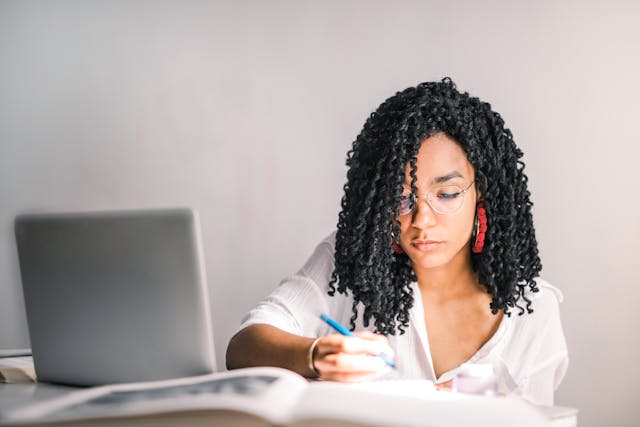 woman at a computer and desk writing stuff