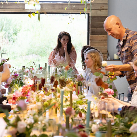 Sophie and workshop attendee's chatting, laughing and arranging their flowers