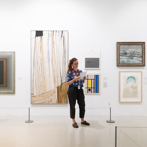 Museum exhibitor standing in front of artwork at The Tate, St. Ives