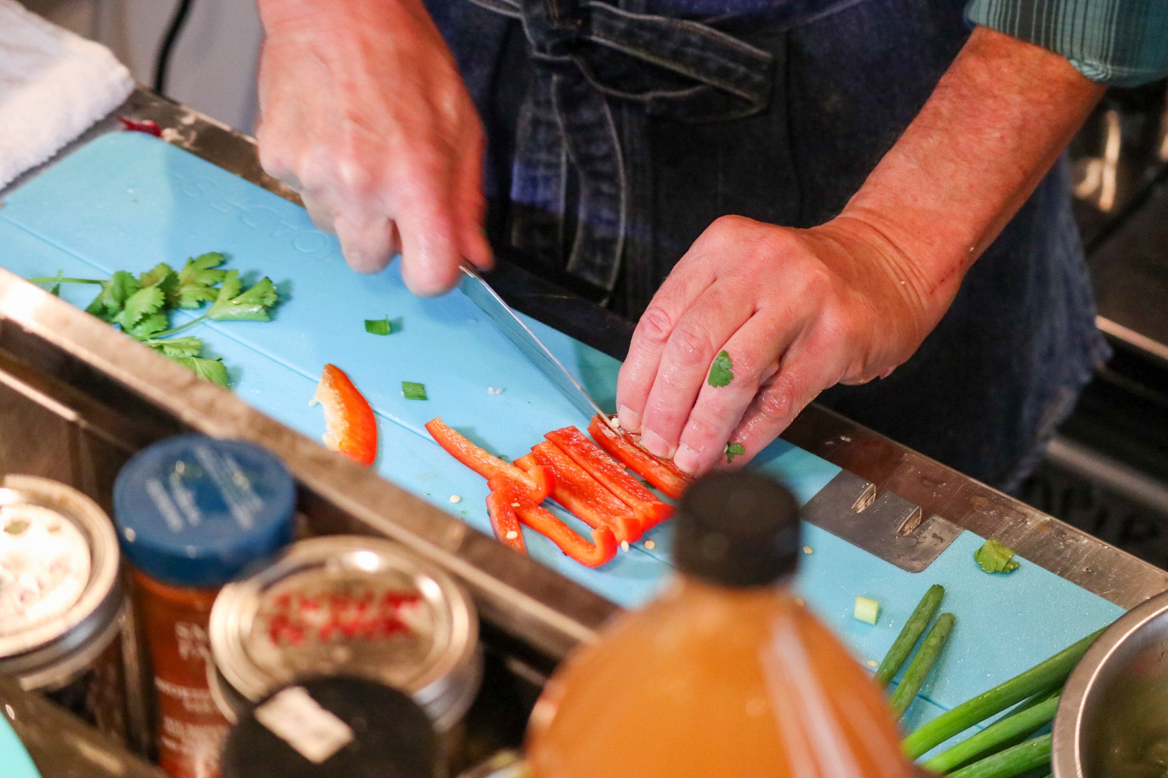 Chef chopping vegetables on Toadfish Stowaway Cutting Board