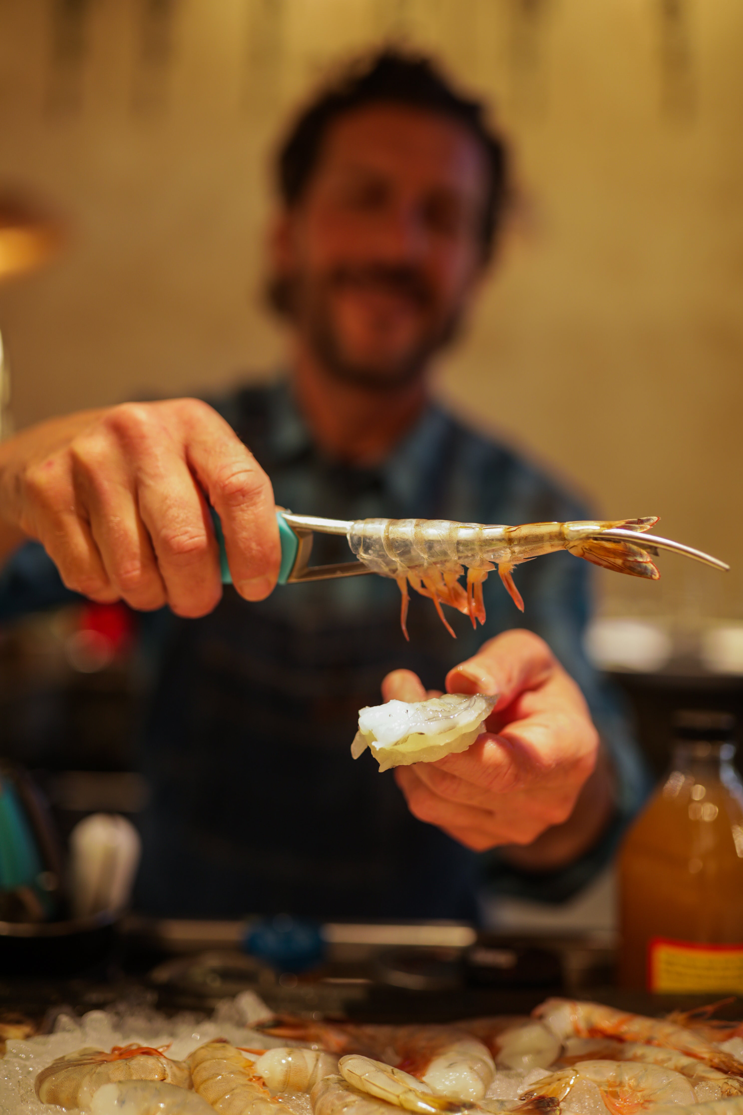 Chef holding peeled shrimp with Toadfish Frogmore Shrimp Cleaner