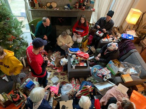 A photo of a family gathered around a Christmas tree opening presents