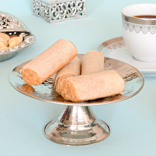 4 pieces of almond fingers on a stainless steel tray and a cup of coffee