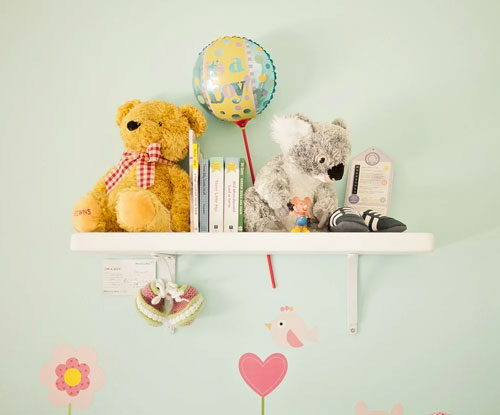 nursery shelf with stuffed animals and other decor