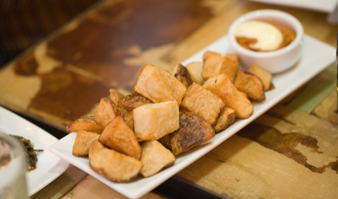 platter of Spanish patatas bravas with dipping sauce