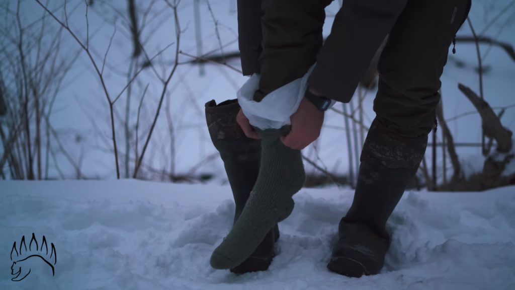 Person wearing an insulating sock over a plastic moisture barrier