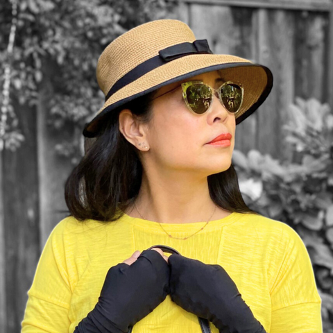 Heliades Fashion Sun Protection_Woman wearing straw hat with bow, yellow shirt and sun protective UV Sun Gauntlets on hands