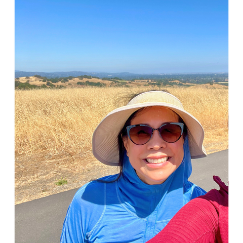 The author wearing her blue sun protective running pullover, hat and sunglasses on The Dish trail in Stanford, CA