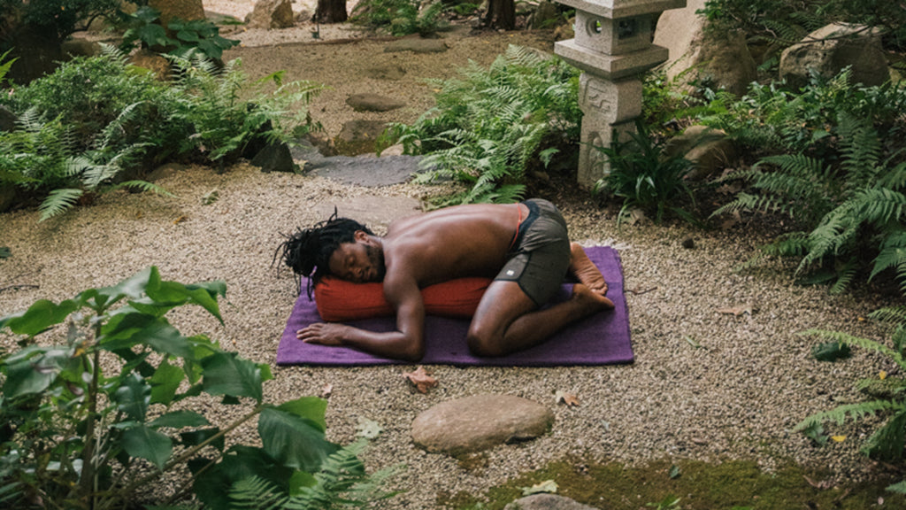 Yoga Instructor Wearing Vuori Banks Shorts in Oregano Splatter in Supported Child's Pose