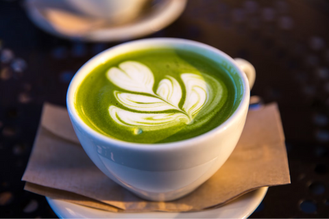 An image of a Matcha latte in a white cup and a latte art flower on top. Not the best tea for weight loss due to its high calorie content