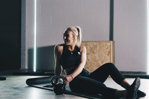 a gym woman sitting in her gym kit