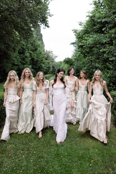 photo of bridesmaids walking with bride in garden