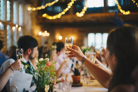 People toasting at a wedding /  Photo by Alisdair Elmes on Unsplash