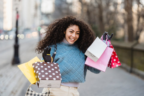 Young woman on the street with shopping bags smiling