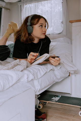 Teenage girl on bed listening to music