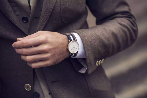 A person wearing a watch with a NATO strap and a casual outfit