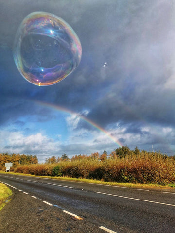 Dr Zigs Eco Ethical Bubble flying over a road with a rainbow behind it