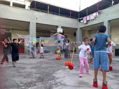 Kurdish Yazidi and Afghan girls and children playing with Dr Zigs Eco Bubbles in a Refugee Camp