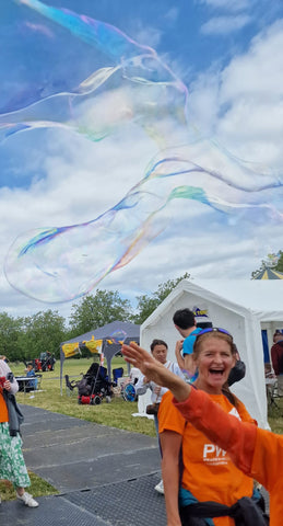 kid reaches up to pop a dr zigs bubble at parallel windsor whilst woman watches on with a big smile