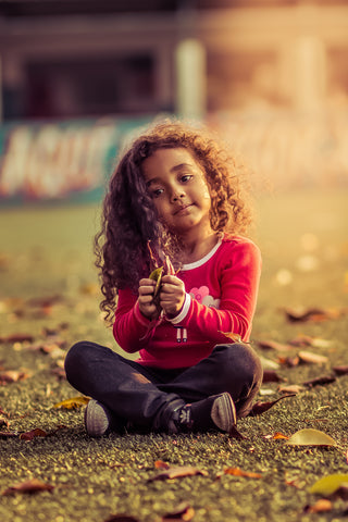 curly hair girl sitting cross legged