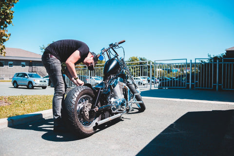 man maintaining his motorcycle tires