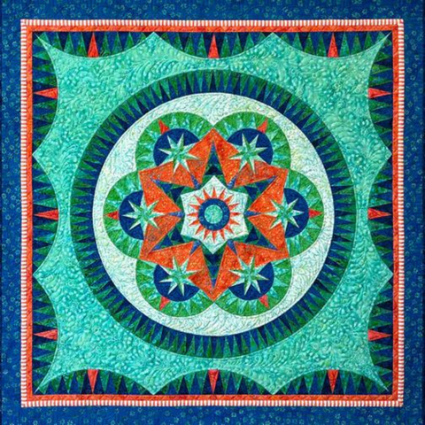 A green and blue paper pieced batik quilt with a star design