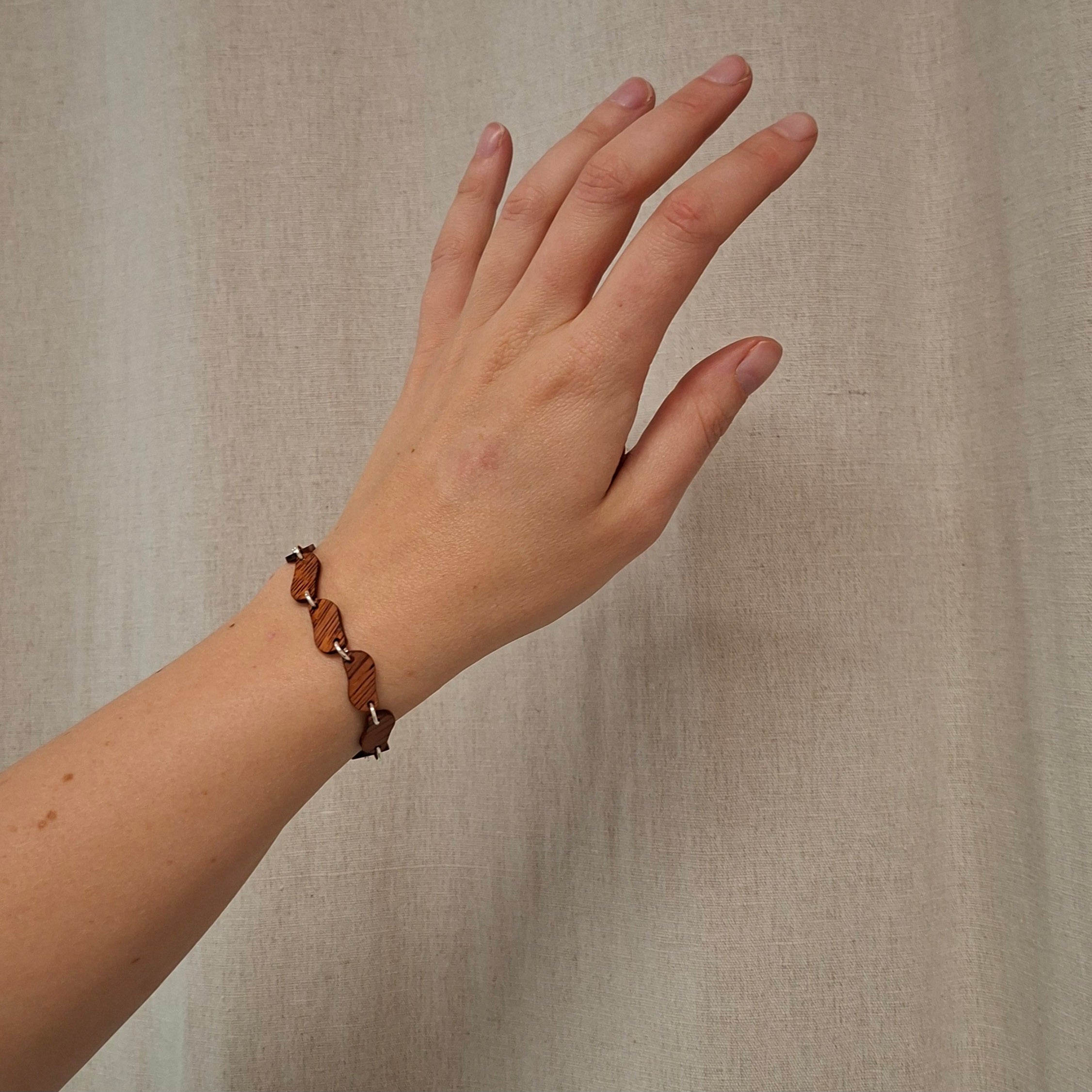 Handgemaakte houten armband van merbau resthout en zilver uit het TimberRing atelier. Elk schakeltje is uniek in tekening.