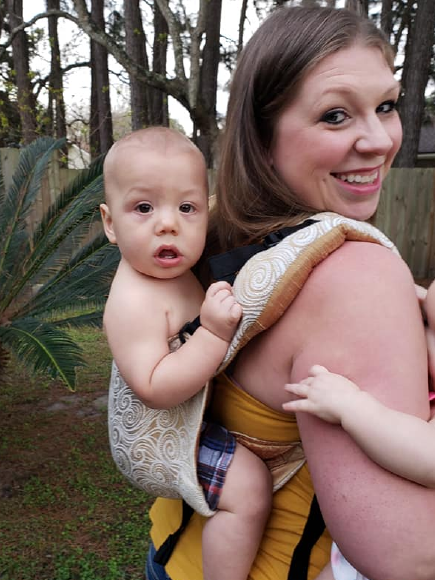 mom wearing baby on the back using a naked panda designs onbuhimo baby carrier