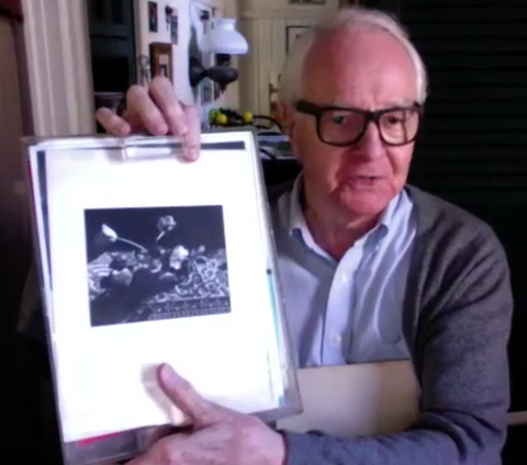 Vance Stevens holds up a plastic portfolio of Irene Fay photographs