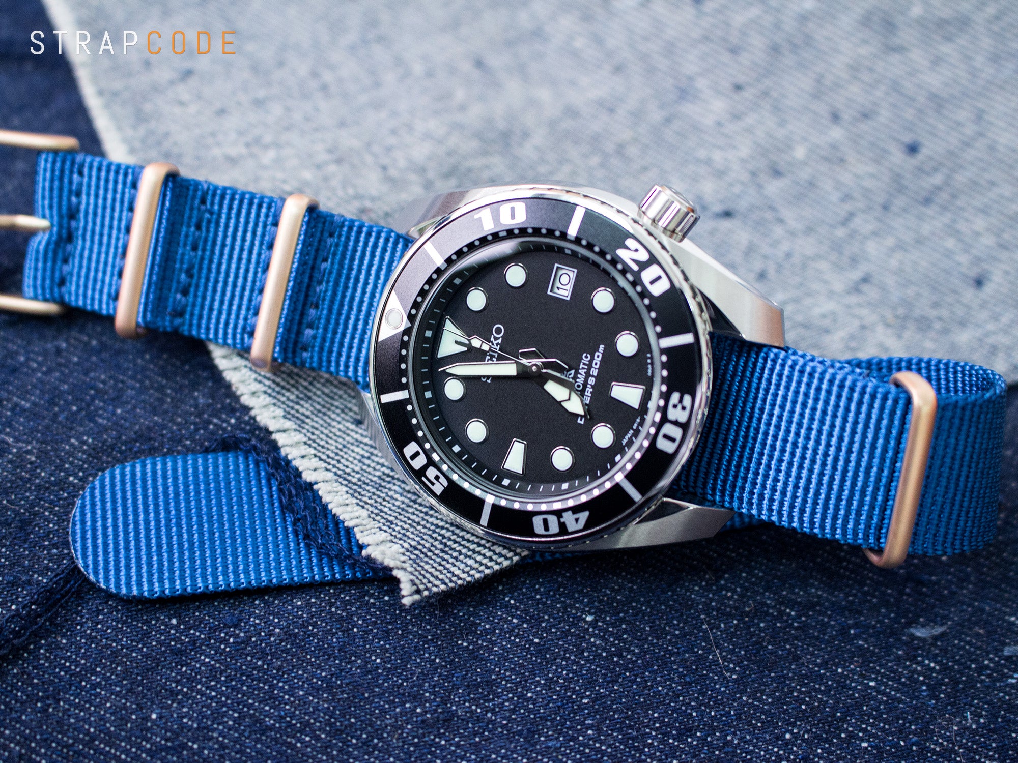 The 2nd Gen Seiko Sumo SBDC031 with a plain Blue NATO strap Champagne gold buckle by Strapcode watch bands