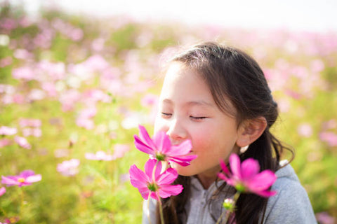 child smelling flowers