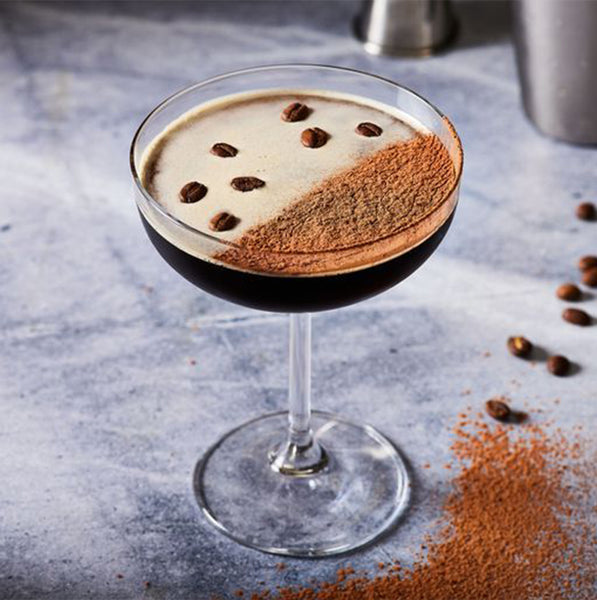 Espresso martini cocktail with coffee beans and espresso powder garnish with a link to the recipe