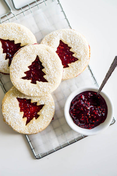 linzer cookies with christmas tree cutout with link to recipe