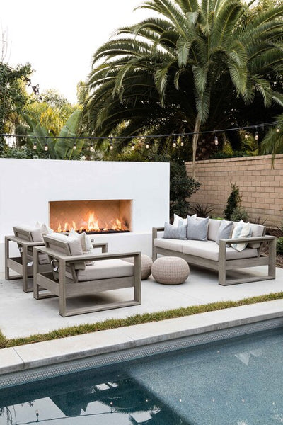 Outdoor patio near a pool with large fireplace and outdoor seating for living outdoors in your home